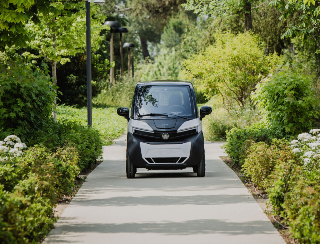 Voiture sans permis électrique garée sur une allée arborée dans un parc résidentiel