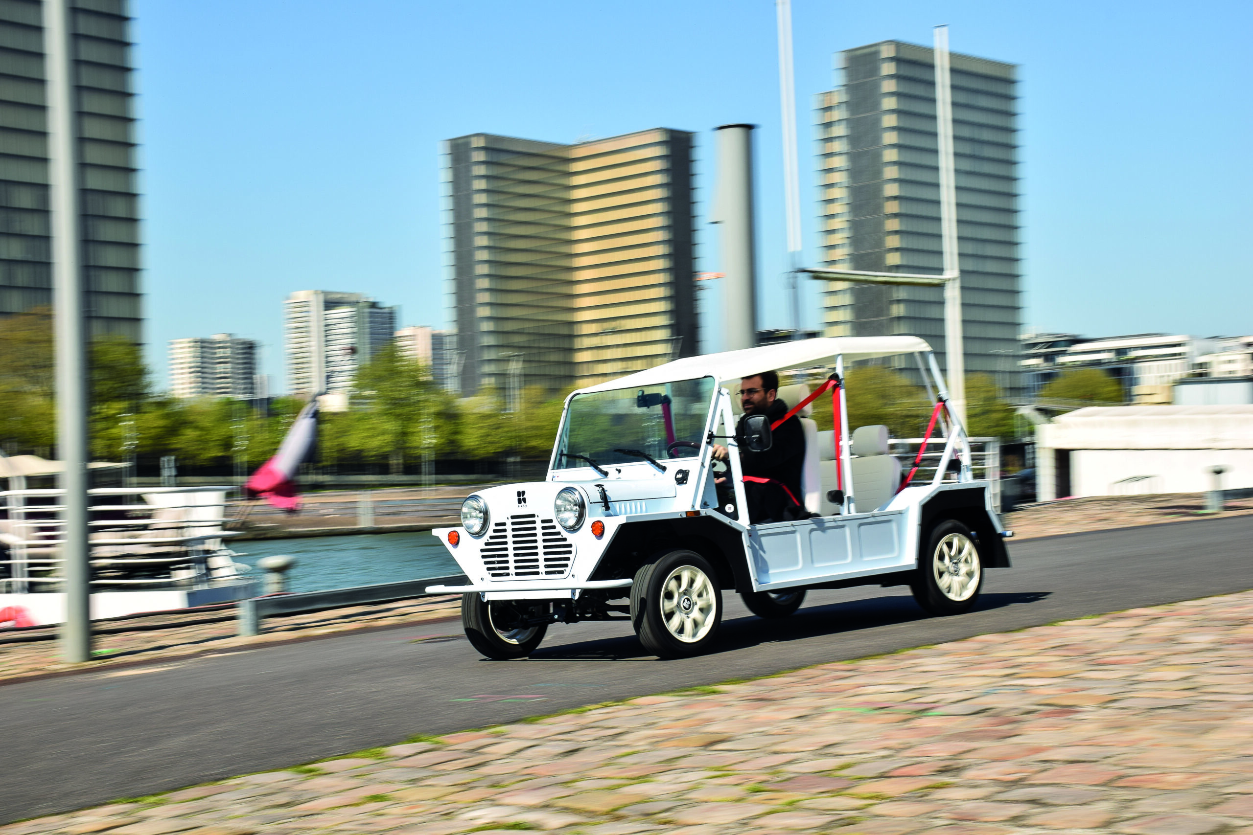 Kate voiture électrique style Mini Moke en circulation en milieu urbain