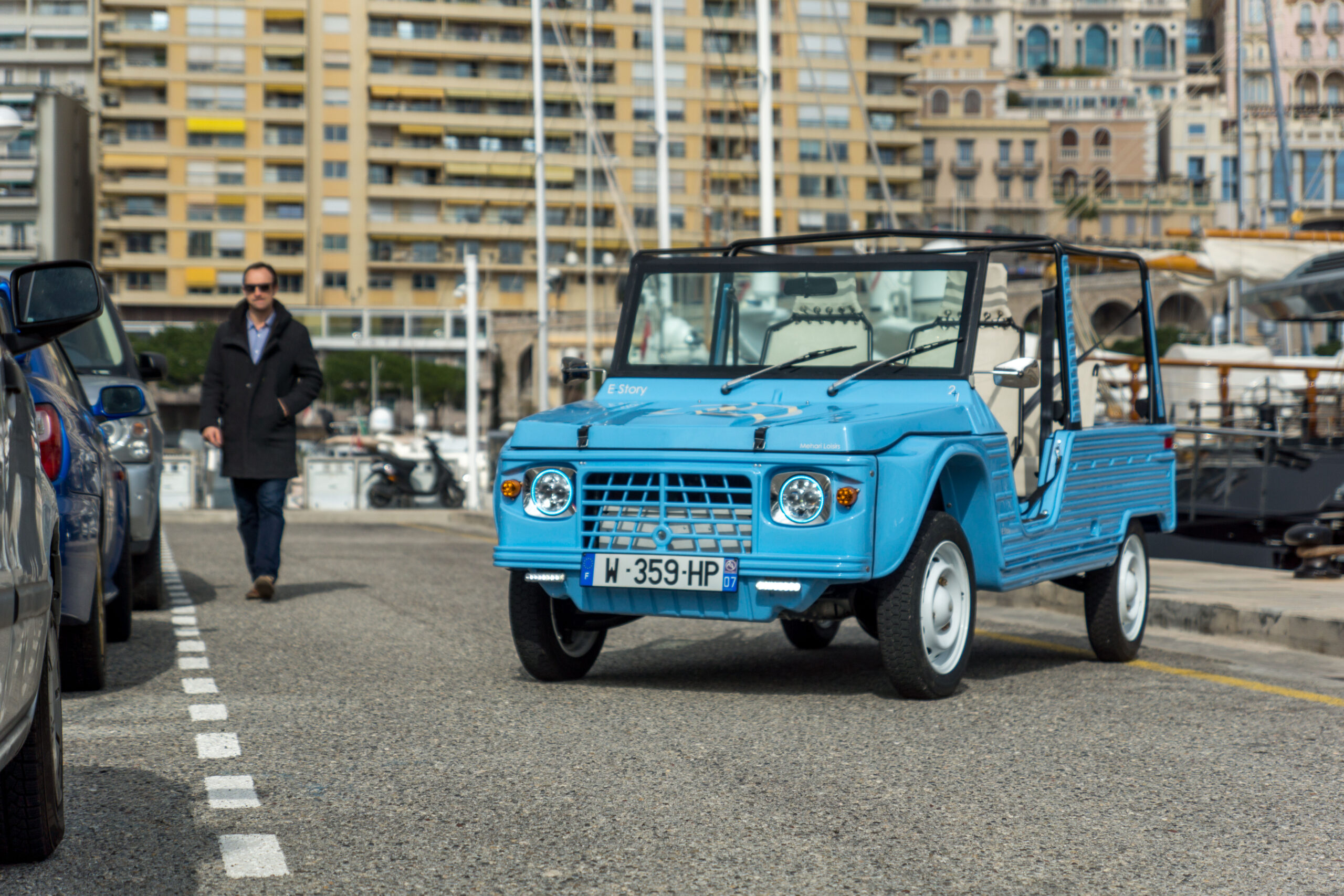 Méhari électrique eStory bleue stationnée en ville, version moderne de la Méhari classique