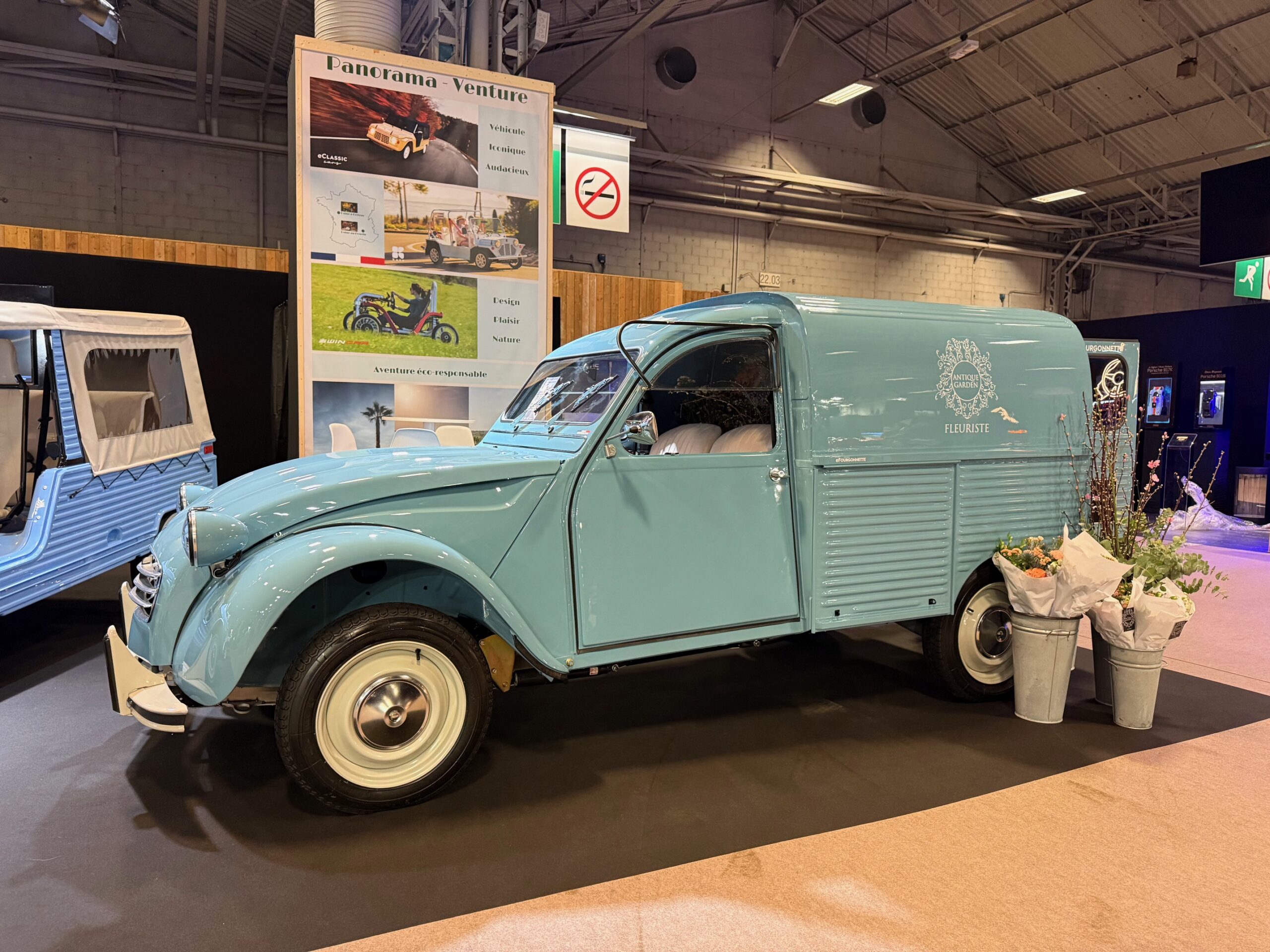 2CV fourgonnette électrique eClassic bleu exposée sur un stand lors d’un salon